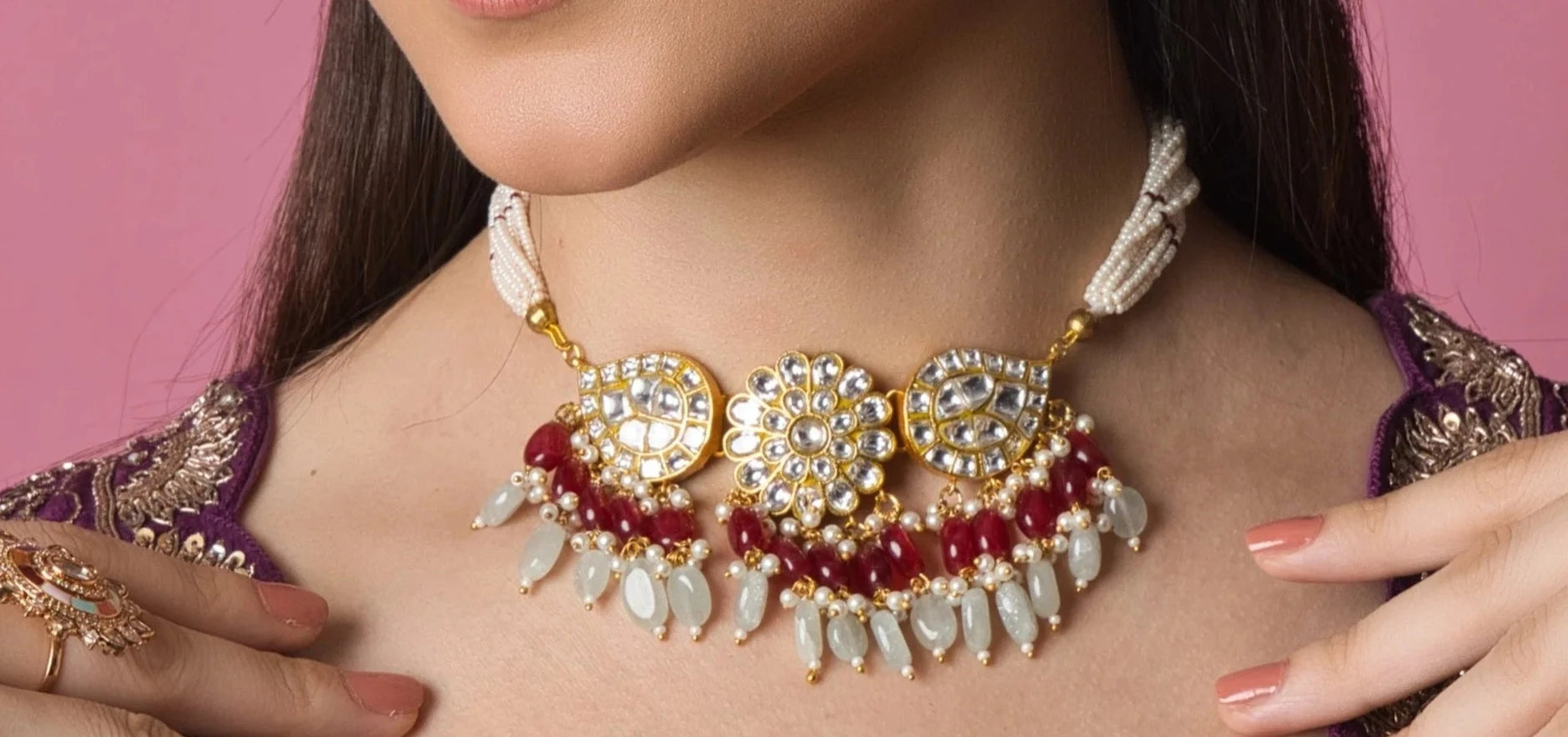 A small Kundan choker with intricate red and white Kundan stones in a droplet design, perfect for festive occasions and bridal wear.