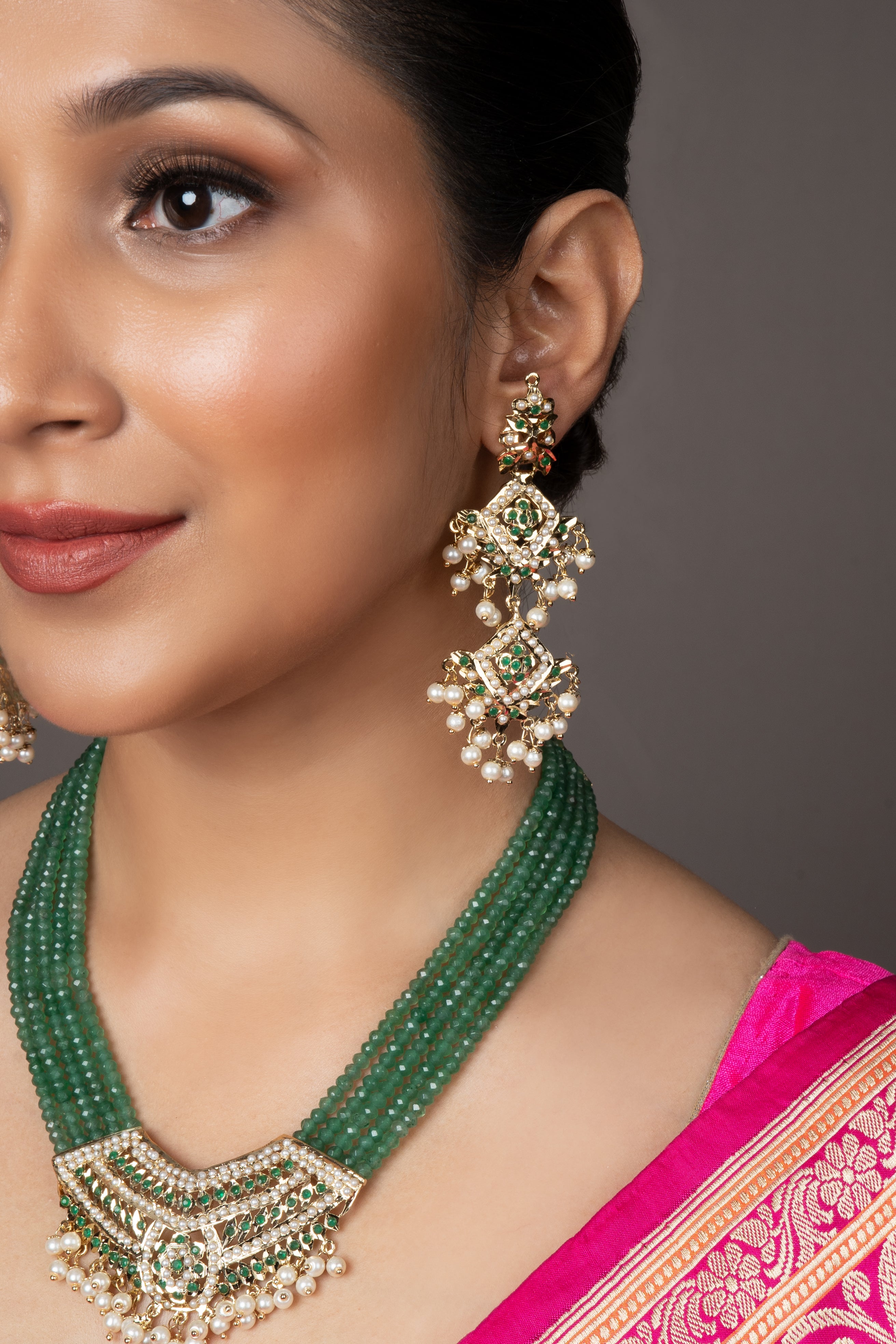 Green Tanmaniya Necklace Set with intricate pendant, adjustable dori for perfect fit, and push-button closure earrings.